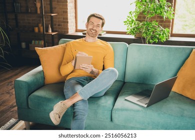 Photo portrait of nice young man sit couch online study write notebook wear yellow clothes modern interior flat indoors