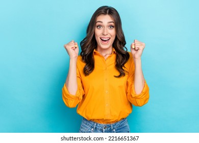 Photo Portrait Of Nice Young Woman Raise Fists Celebrate Award Lucky Wear Trendy Yellow Smart Casual Look Isolated On Blue Color Background