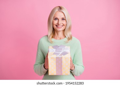 Photo Portrait Of Old Lady Holding Yellow Dotted Present Box Isolated On Pastel Pink Colored Background