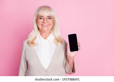 Photo Portrait Of Old Lady Showing Phone In One Hand With Blank Space Isolated On Pastel Pink Colored Background