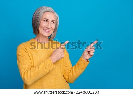 Photo portrait of old stunning grandma pointing empty space businesswoman banner wear trendy yellow look isolated on blue color background