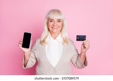 Photo Portrait Of Old Woman Holding Phone With Blank Space Credit Card Isolated On Pastel Pink Colored Background