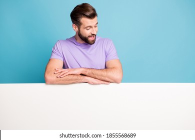 Photo portrait of positive man looking down keeping hands on white blank space surprised isolated bright blue color background