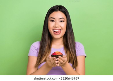 Photo portrait of pretty japanese korean young girl muffin lick teeth yummy wear trendy purple outfit isolated on green color background