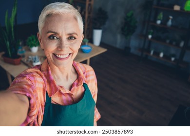 Photo portrait of pretty senior female professional florist take selfie photo smile wear apron working flower shop delivery