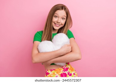 Photo portrait of pretty teenager girl hugging heart pillow dressed stylish green outfit isolated on pink color background - Powered by Shutterstock