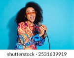 Photo portrait of pretty young girl sing karaoke mic wear trendy colorful outfit isolated on blue color background