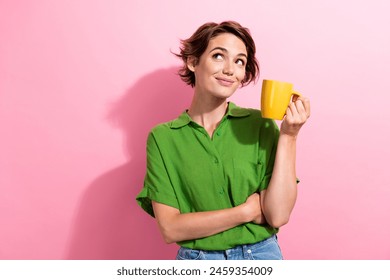 Photo portrait of pretty young girl hold coffee mug look empty space dressed stylish green outfit isolated on pink color background - Powered by Shutterstock