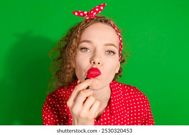 Photo portrait of pretty young girl apply pomade lips wear trendy red retro outfit isolated on green color background - Powered by Shutterstock