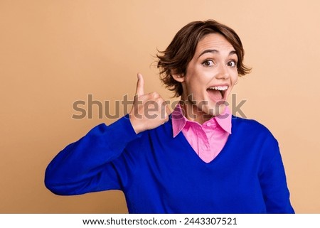 Photo portrait of pretty young girl show excited thumb up dressed stylish blue outfit isolated on beige color background
