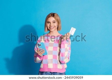Photo portrait of pretty young girl hold gadget credit card paying wear trendy pink outfit isolated on blue color background