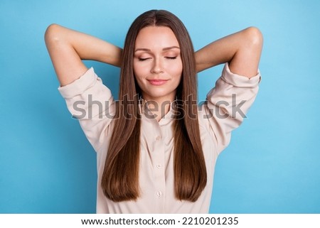 Photo portrait of pretty young lady closed eyes hands behind head take nap wear stylish smart casual look isolated on blue color background