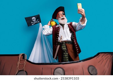 Photo portrait of senior funny pirate grandpa take selfie photo wear masquerade party costume isolated blue color background - Powered by Shutterstock