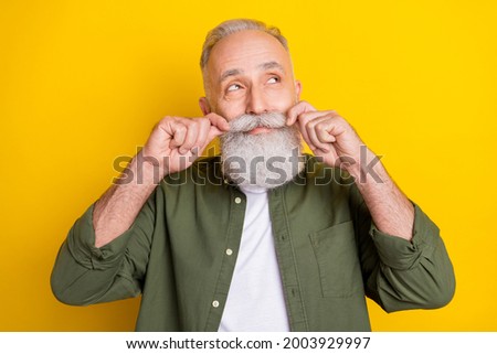 Photo portrait of senior man touching mustache looking dreamy empty space isolated vibrant yellow color background