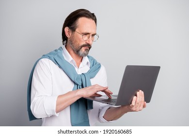 Photo portrait of serious focused businessman entrepreneur working on laptop wearing glasses isolated pastel grey color background - Powered by Shutterstock