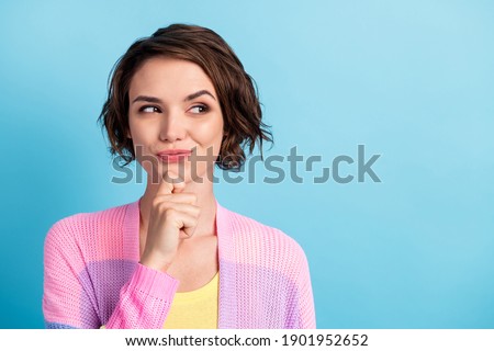 Photo portrait of sly girl touching face chin with finger looking at blank space isolated on pastel blue colored background