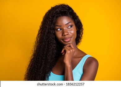 Photo portrait of smart clever african american woman looking to side touching chin with finger isolated on bright yellow colored background - Powered by Shutterstock