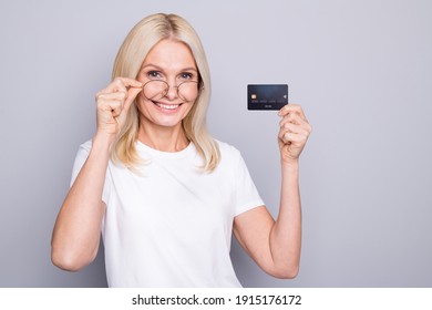 Photo Portrait Of Smiling Old Lady Taking Off Glasses Holding Credit Card In One Hand Isolated On Grey Colored Background