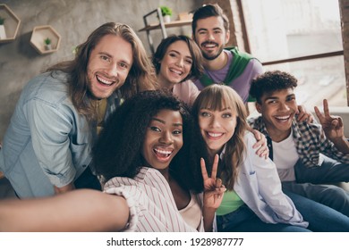 Photo portrait of smiling students showing v-sign gestures taking selfie sitting on sofa embracing together - Powered by Shutterstock