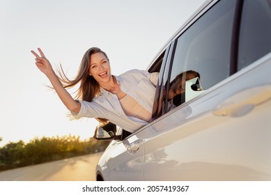 Photo Portrait Smiling Woman Riding In Car With Flying On Wind Hair Showing V-sign Gesture