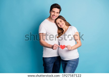 Photo portrait of two people couple husband pregnant wife hugging holding red heart card isolated bright blue color background