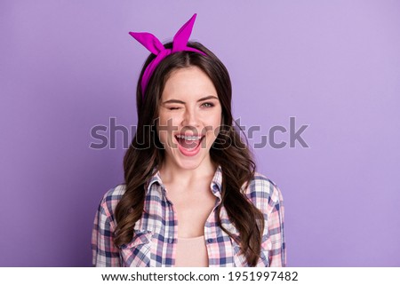 Photo portrait of winking girl isolated on vivid purple colored background