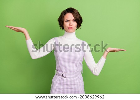 Photo portrait woman comparing empty space on palms doubt unsure isolated pastel green color background