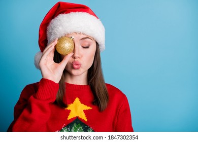 Photo Portrait Of Woman Holding Christmas Bauble Near Eye Sending Kiss Isolated On Pastel Light Blue Colored Background