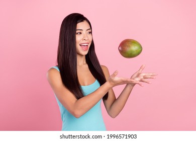 Photo portrait woman smiling keeping exotic fruit throwing in air isolated pastel pink color background