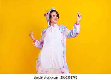Photo portrait woman in unicorn costume dancing on pajama party isolated vibrant yellow color background