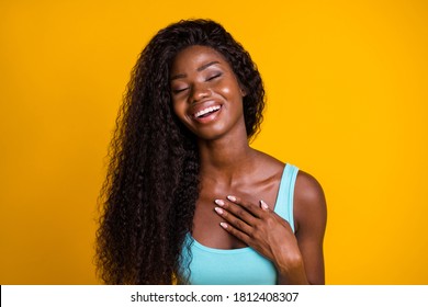 Photo Portrait Of Young African American Woman Sighing In Relief Touching Chest With Hand Isolated On Vivid Yellow Colored Background