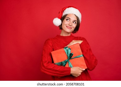 Photo portrait young woman keeping xmas gift in headwear looking copyspace isolated bright red color background - Shutterstock ID 2058708101