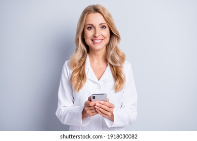 Photo of positive attractive lady hands hold phone toothy smile look camera isolated on grey color background - Powered by Shutterstock