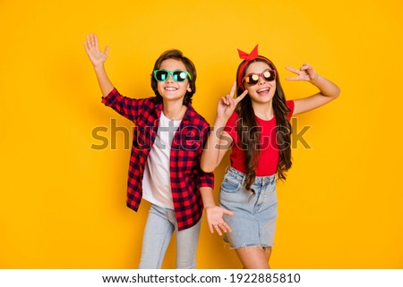 Photo of positive boy hands palms girl fingers show v-sign have good mood isolated on yellow color background