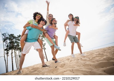 Photo of positive carefree fellows company walking having fun together smiling outside seaside beach - Powered by Shutterstock