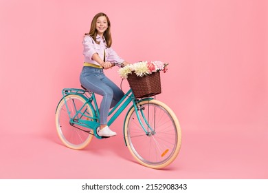 Photo of positive carefree lady drive bicycle toothy beaming smile wear jacket isolated pink color background