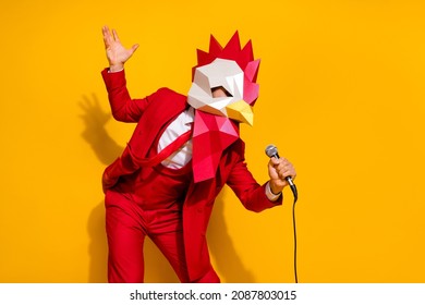 Photo of positive charismatic guy hold mic sing song wear rooster mask red suit isolated yellow color background - Shutterstock ID 2087803015