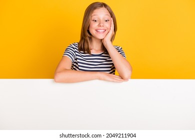Photo of positive charming person hand on cheek look interested down empty space isolated on yellow color background