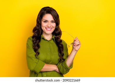 Photo Of Positive Cheerful Agent Lady Take Off Eyeglasses Shiny Smile Wear Green Shirt Isolated Yellow Color Background