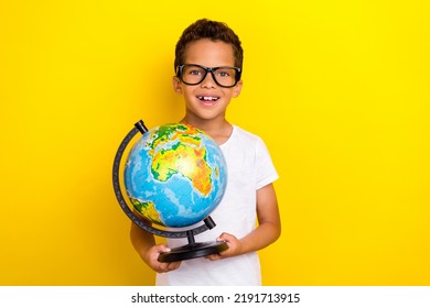 Photo of positive cheerful boy student first lesson hold globe earth isolated on yellow color background - Powered by Shutterstock