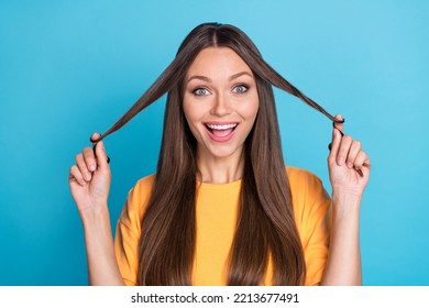 Photo Of Positive Cheerful Cute Lady Wear Yellow Clothes Hand Arm Touch Strand Hair Isolated On Blue Color Background