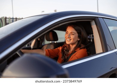 Photo of positive cheerful girl funky driver rider enjoy drive ride car under pop star hits playlist music try dance raise hands in city center - Powered by Shutterstock