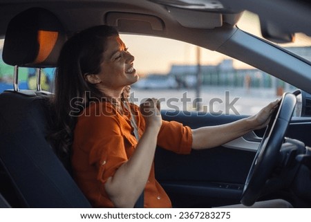 Photo of positive cheerful girl ride drive car town route wait traffic jam listen, music sound try dance feel excited