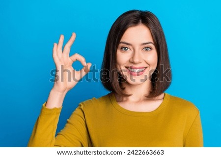 Photo of positive confident woman wear shirt smiling showing okey gesture isolated blue color background