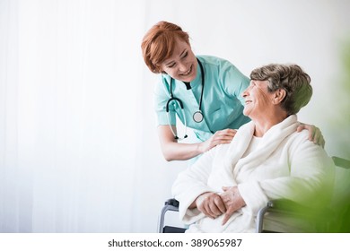 Photo Of Positive Doctor And Patient On Wheelchair