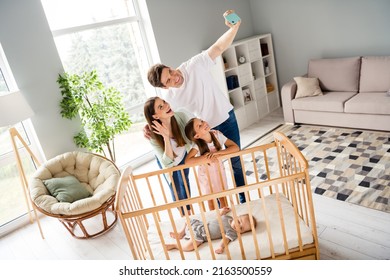 Photo Of Positive Excited Family Make Selfie Hand Wave Hello Greetings Toddler Sleep Crib Home Indoors