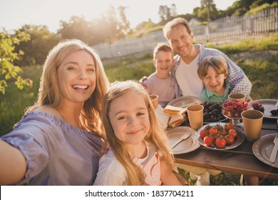 Photo of positive family people mom mommy daddy dad small kids girls boys preteen sit countryside lunch meal make selfie enjoy relax weekend outdoors - Powered by Shutterstock