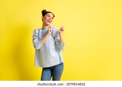 Photo of positive funny lady look empty space dance wear blue sweater jeans isolated yellow background - Shutterstock ID 2079814810