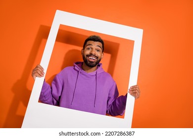 Photo Of Positive Funny Man Hands Hold Paper Window Toothy Smile Isolated On Orange Color Background