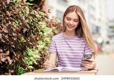 Photo of positive good mood girl dressed purple t-shirt sitting cafe communicating modern gadget outdoors uban city town - Powered by Shutterstock